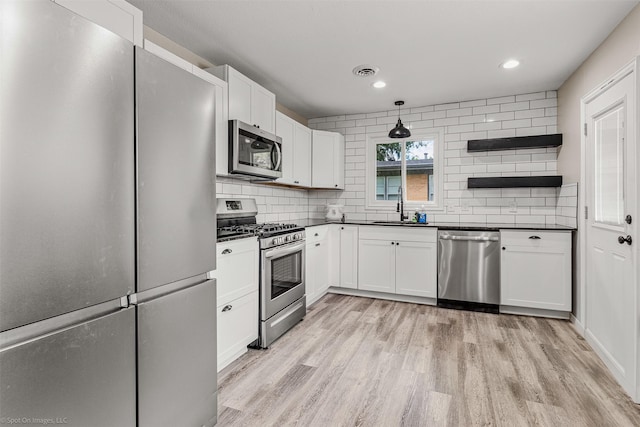 1701 W College St, Sherman, TX 75092 - kitchen featuring appliances with stainless steel finishes, a sink, dark countertops, open shelves, and recessed lighting