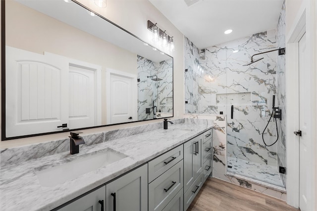 600 Arthur St, Mcgregor, TX 76657 - bathroom with a marble finish shower, double vanity, recessed lighting, and wood finished floors