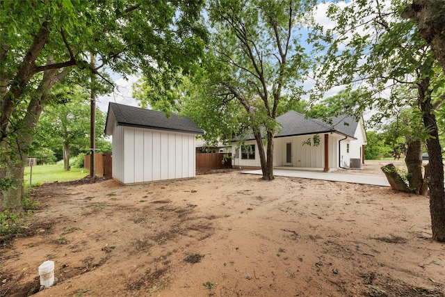 600 Arthur St, Mcgregor, TX 76657 - rear view of house featuring an outbuilding, fence, a shed, central AC unit, and a shingled roof