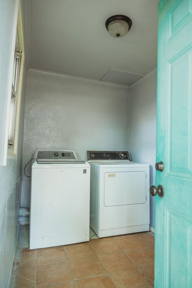 washroom featuring washer and dryer, crown molding, light tile patterned flooring, and attic access