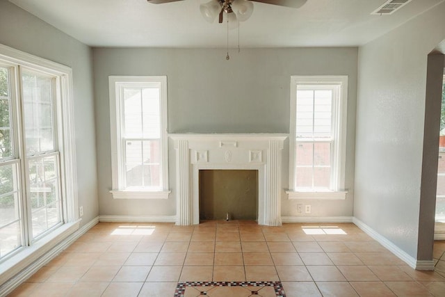 unfurnished living room featuring light tile patterned floors, ceiling fan, and baseboards