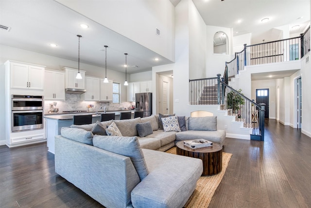 6108 Lipan Ln, Mckinney, TX 75070 - living area featuring stairway, dark wood-style flooring, a high ceiling, and baseboards