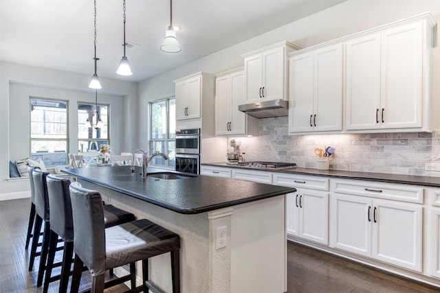 6108 Lipan Ln, Mckinney, TX 75070 - kitchen with dark countertops, stainless steel appliances, a sink, decorative backsplash, and a kitchen bar