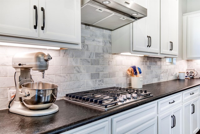 6108 Lipan Ln, Mckinney, TX 75070 - kitchen featuring wall chimney range hood, stainless steel gas stovetop, dark countertops, white cabinetry, and tasteful backsplash