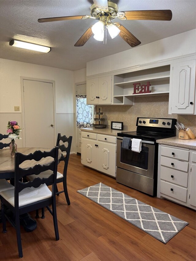kitchen with electric stove, open shelves, white cabinets, backsplash, and a textured ceiling