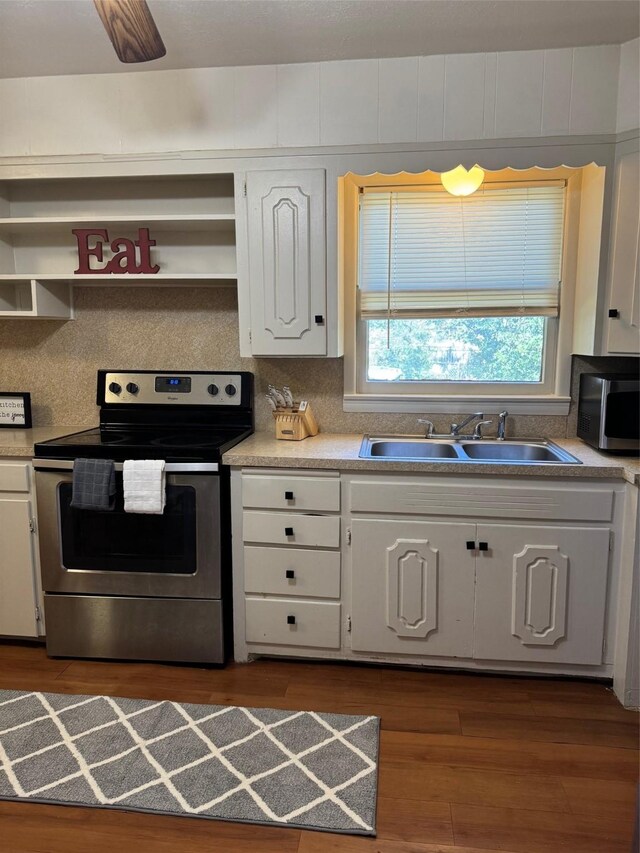 kitchen featuring appliances with stainless steel finishes, a sink, light countertops, white cabinetry, and open shelves