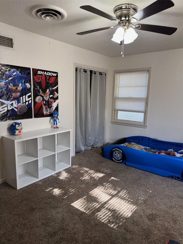 unfurnished bedroom with carpet, a textured ceiling, and ceiling fan