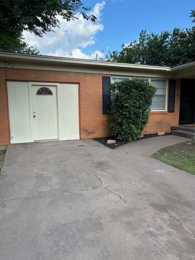 doorway to property featuring brick siding