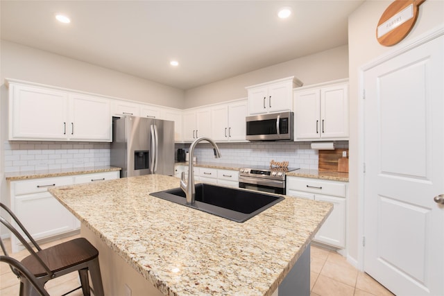 9332 Castorian Dr, Fort Worth, TX 76131 - kitchen featuring stainless steel appliances, a sink, backsplash, a center island with sink, and white cabinets