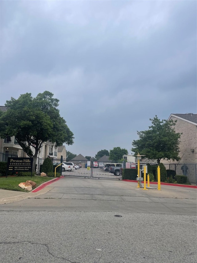 5881 Preston View Blvd Unit 121, Dallas, TX 75240 - view of asphalt street featuring a gate, curbs, and a gated entry