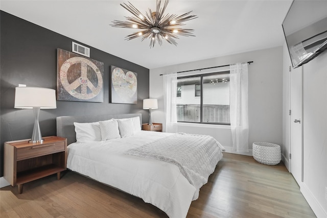11641 Sasanqua Ln, Dallas, TX 75218 - bedroom with a chandelier, wood finished floors, and baseboards