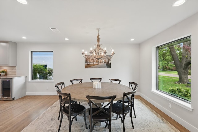 11641 Sasanqua Ln, Dallas, TX 75218 - dining space featuring wine cooler, light wood-style floors, baseboards, recessed lighting, and a chandelier