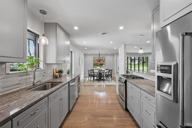 11641 Sasanqua Ln, Dallas, TX 75218 - kitchen with stainless steel appliances, a sink, stone counters, decorative backsplash, and light wood-type flooring