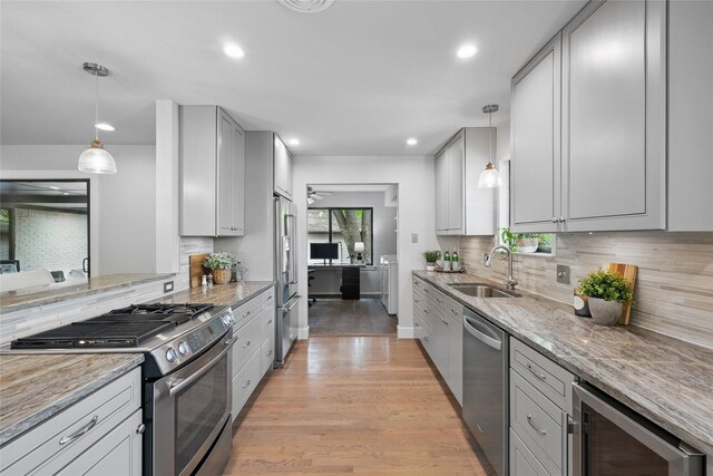 11641 Sasanqua Ln, Dallas, TX 75218 - kitchen with stainless steel appliances, a sink, independent washer and dryer, wine cooler, and light stone countertops