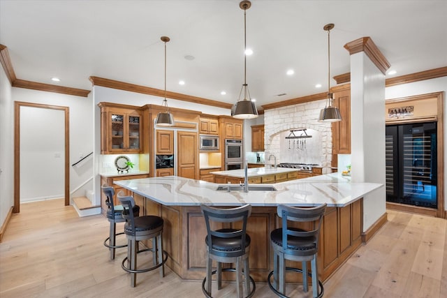 kitchen with wine cooler, stainless steel appliances, a sink, ornamental molding, and baseboards