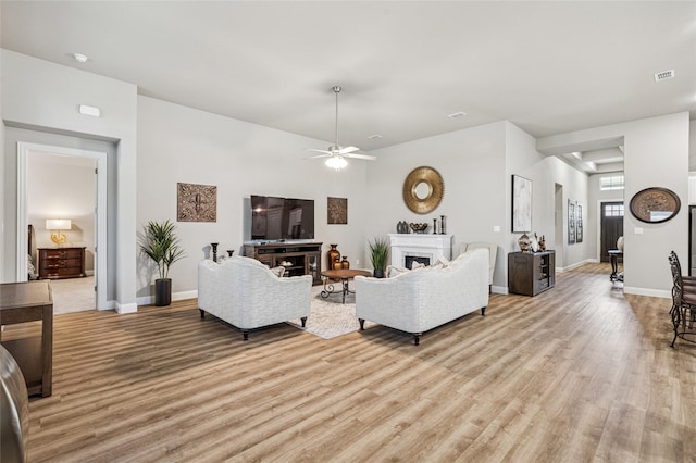 810 Brenda Dr, Mansfield, TX 76063 - living room featuring light wood-style flooring, a ceiling fan, a fireplace, and baseboards