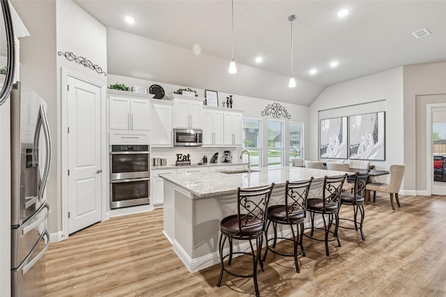 810 Brenda Dr, Mansfield, TX 76063 - kitchen featuring appliances with stainless steel finishes, a sink, lofted ceiling, a breakfast bar, and light wood-style floors