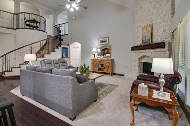 6001 Lacebark Elm Dr, Fort Worth, TX 76123 - living area featuring stairway, a high ceiling, a ceiling fan, a fireplace, and arched walkways