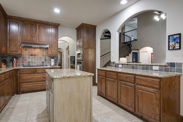 6001 Lacebark Elm Dr, Fort Worth, TX 76123 - kitchen featuring backsplash, light stone countertops, a kitchen island, stainless steel appliances, and recessed lighting