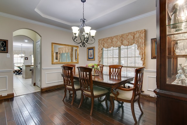 6001 Lacebark Elm Dr, Fort Worth, TX 76123 - dining space featuring a chandelier, a decorative wall, dark wood finished floors, ornamental molding, and arched walkways