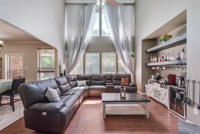 3501 Kasmier Ct, Arlington, TX 76001 - living room featuring crown molding, a bar, ceiling fan, arched walkways, and a towering ceiling