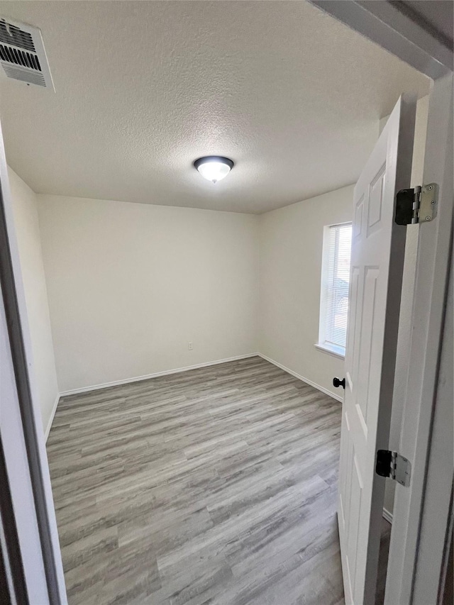 6706 Frontage Rd, Greenville, TX 75402 - unfurnished room featuring wood finished floors, baseboards, and a textured ceiling