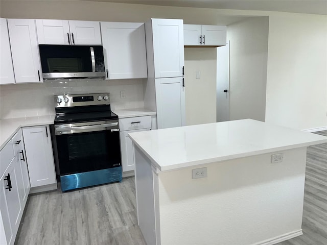 6706 Frontage Rd, Greenville, TX 75402 - kitchen featuring stainless steel appliances, light wood finished floors, white cabinetry, backsplash, and light countertops
