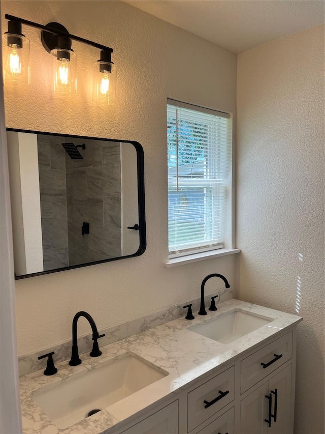 6706 Frontage Rd, Greenville, TX 75402 - bathroom featuring double vanity, a textured wall, and a tile shower
