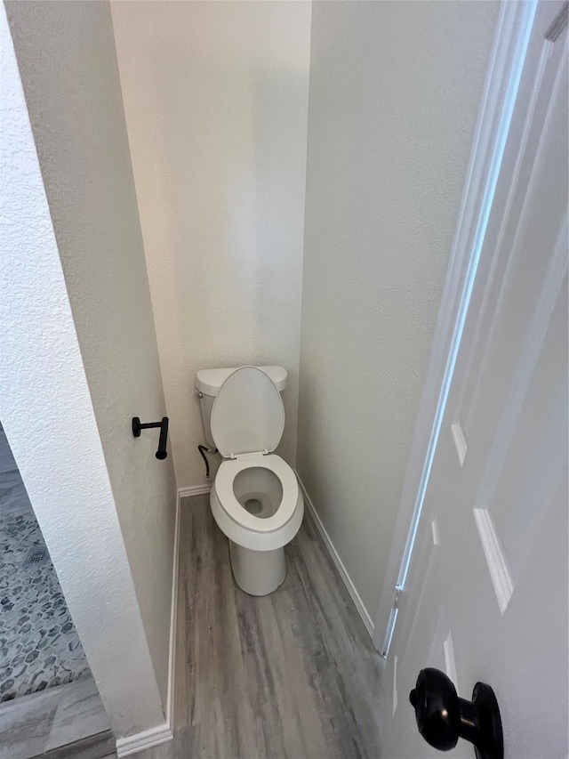 6706 Frontage Rd, Greenville, TX 75402 - bathroom with wood finished floors, toilet, and baseboards