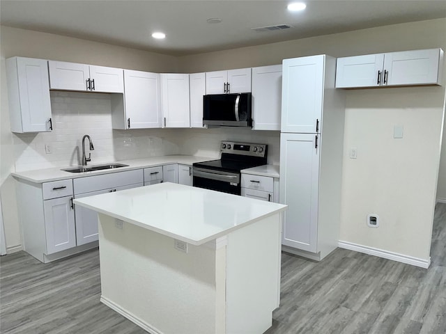 6706 Frontage Rd, Greenville, TX 75402 - kitchen with stainless steel appliances, a sink, light wood-style flooring, backsplash, and recessed lighting