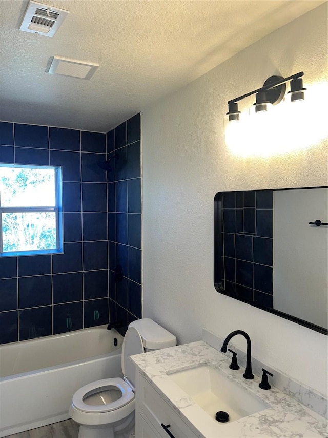 6706 Frontage Rd, Greenville, TX 75402 - full bathroom featuring a textured ceiling, bathing tub / shower combination, toilet, vanity, and a textured wall