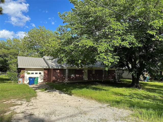 401 S Weatherford St, Chico, TX 76431 - view of property hidden behind natural elements featuring a garage, brick siding, dirt driveway, and a front yard