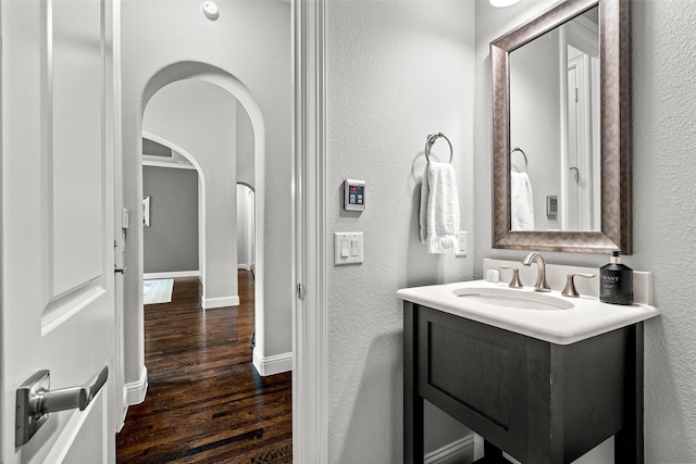 3713 Adelaide, The Colony, TX 75056 - bathroom featuring wood finished floors, vanity, a textured wall, and baseboards