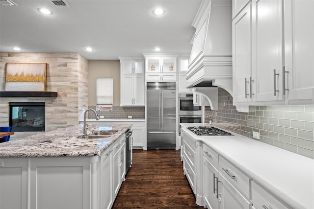 3713 Adelaide, The Colony, TX 75056 - kitchen featuring appliances with stainless steel finishes, a sink, dark wood-style flooring, white cabinets, and tasteful backsplash