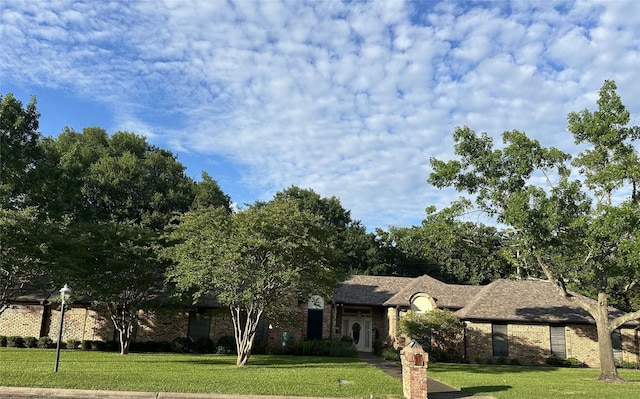 view of front of property featuring brick siding and a front lawn