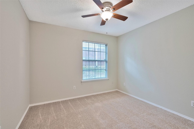 unfurnished room featuring carpet, a ceiling fan, a textured ceiling, and baseboards