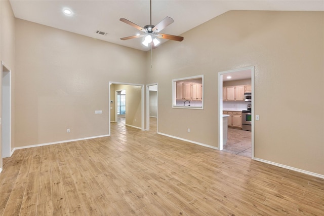 unfurnished living room featuring a ceiling fan, light wood-type flooring, baseboards, and high vaulted ceiling