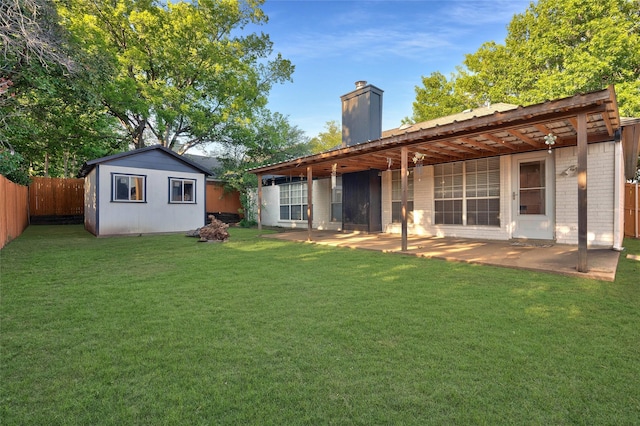 rear view of property featuring a chimney, a patio area, and an outdoor structure