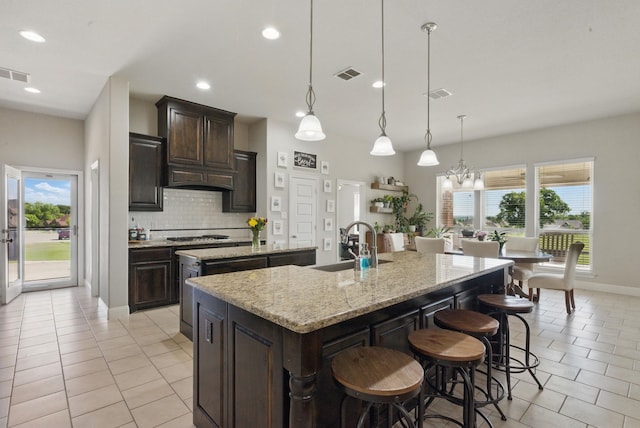 711 Red Stone Ln, Weatherford, TX 76087 - kitchen featuring a kitchen island with sink, a sink, light tile patterned floors, healthy amount of natural light, and recessed lighting