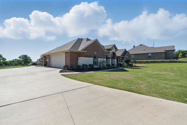 711 Red Stone Ln, Weatherford, TX 76087 - view of front of property featuring a front lawn, brick siding, driveway, an attached garage, and stone siding