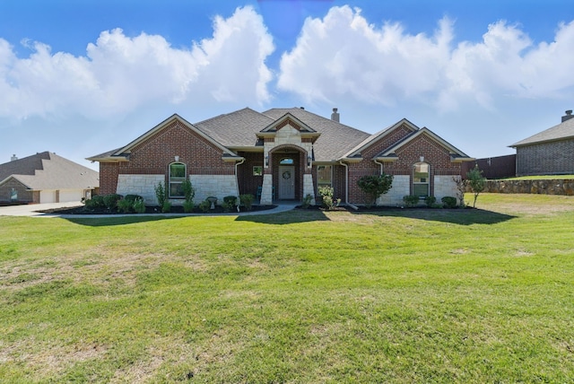 711 Red Stone Ln, Weatherford, TX 76087 - view of front facade featuring stone siding, a front yard, and brick siding