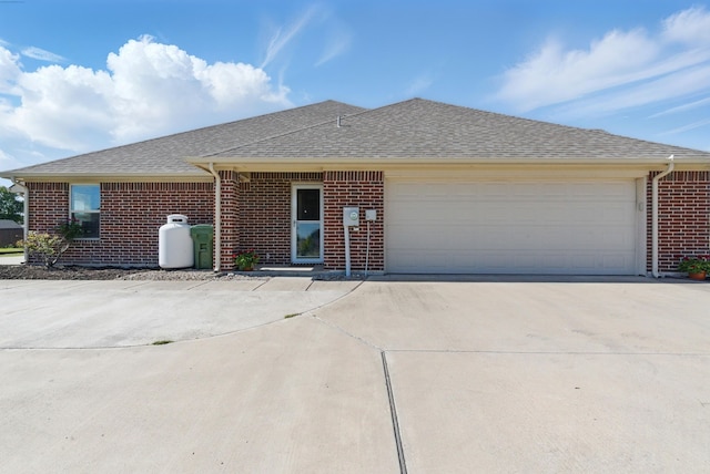 711 Red Stone Ln, Weatherford, TX 76087 - ranch-style home featuring brick siding, concrete driveway, roof with shingles, and a garage