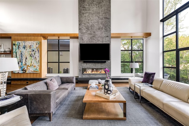 11460 Strait Ln, Dallas, TX 75229 - living area featuring a towering ceiling, healthy amount of natural light, a fireplace, and wood finished floors