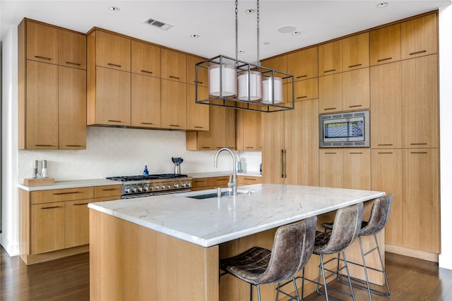 11460 Strait Ln, Dallas, TX 75229 - kitchen with dark wood-type flooring, appliances with stainless steel finishes, a sink, light stone countertops, and recessed lighting