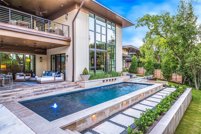 11460 Strait Ln, Dallas, TX 75229 - back of house with a balcony, a ceiling fan, an outdoor pool, outdoor lounge area, and stucco siding