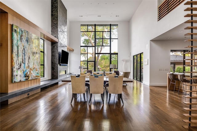 11460 Strait Ln, Dallas, TX 75229 - dining space with a towering ceiling, wood finished floors, a fireplace, and baseboards