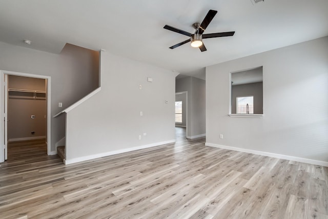 4007 Freedom St, Heartland, TX 75126 - unfurnished living room with ceiling fan, light wood finished floors, baseboards, and stairway