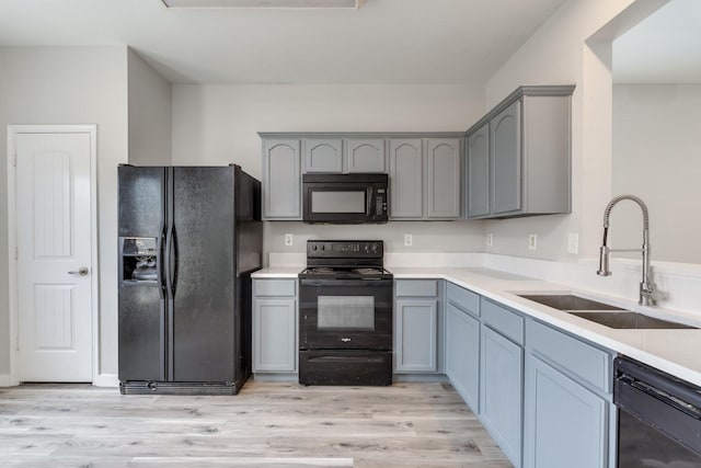 4007 Freedom St, Heartland, TX 75126 - kitchen with black appliances, a sink, gray cabinets, and light wood finished floors