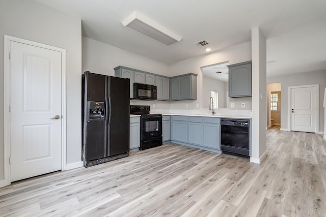 4007 Freedom St, Heartland, TX 75126 - kitchen with black appliances, a sink, light countertops, light wood-type flooring, and gray cabinets