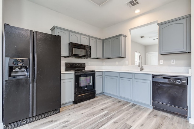 4007 Freedom St, Heartland, TX 75126 - kitchen with black appliances, a sink, light wood-style flooring, light countertops, and gray cabinets